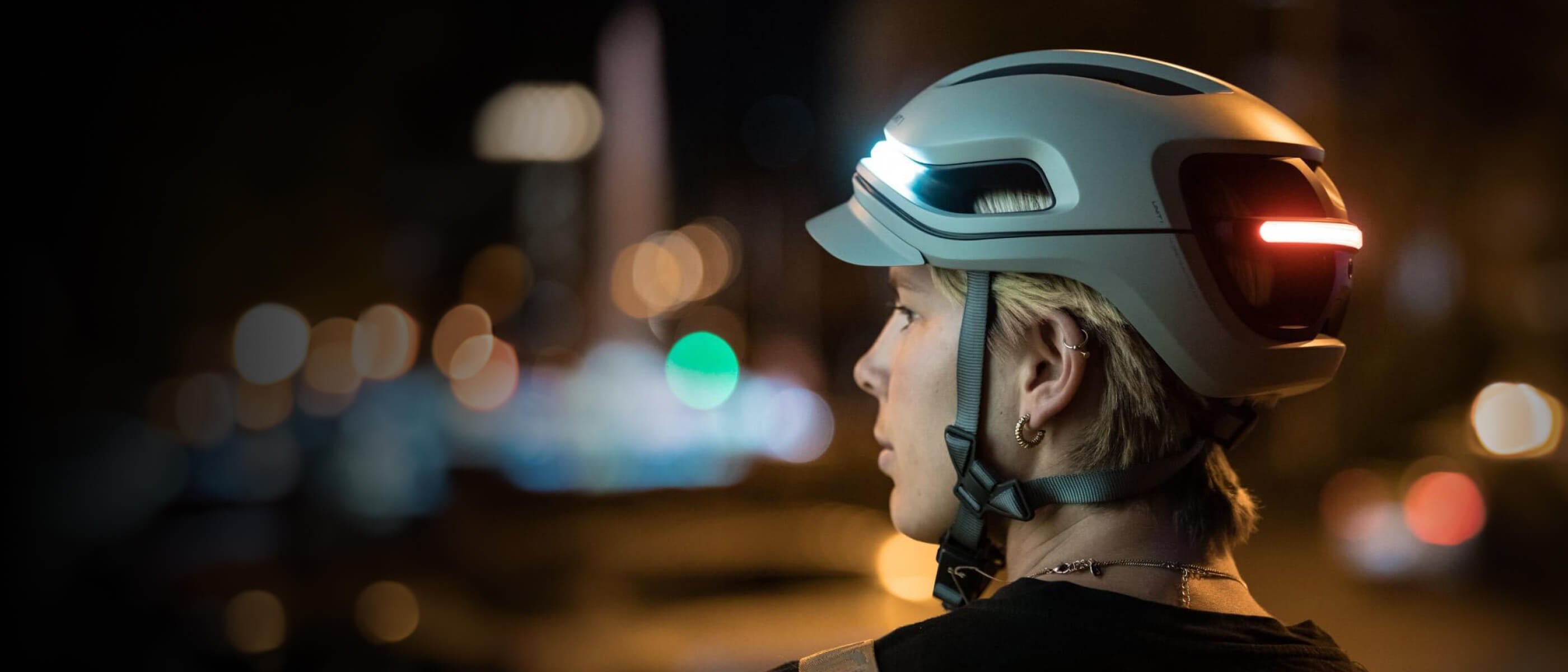 Female bicycle rider wearing aura mips turn signals smart helmet lights